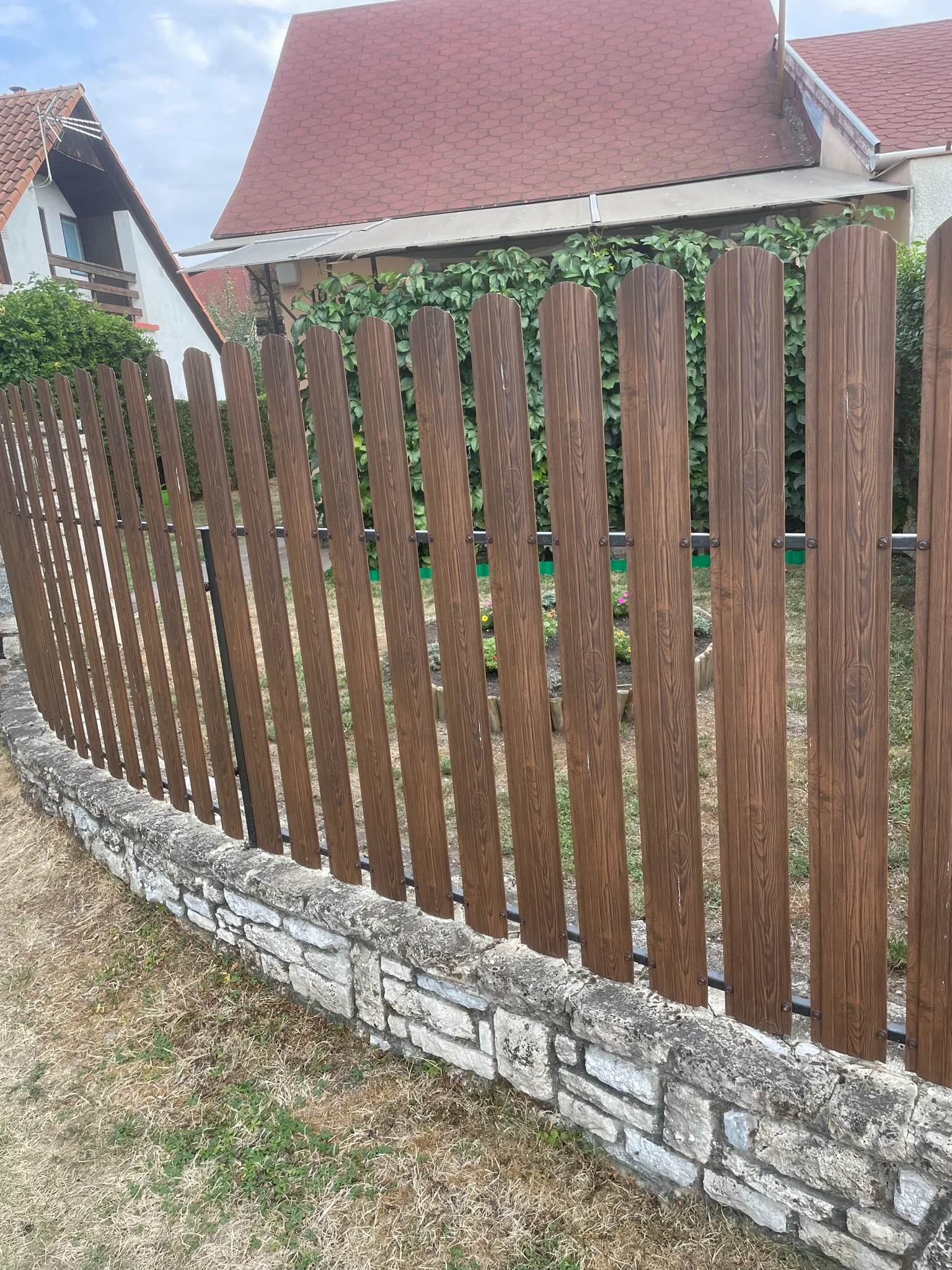 Fa léces kerítés kőburkolatú lábazattal